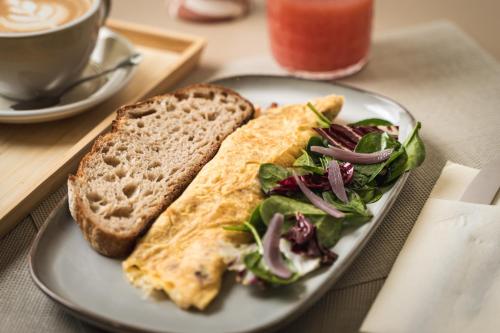 a plate with an omelet and a sandwich and a salad at Emerald Residence Apartments in Dunajská Streda