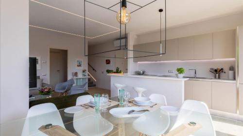 a dining room and kitchen with a glass table and chairs at Luxury Apartments in Modern Villa in Imperia