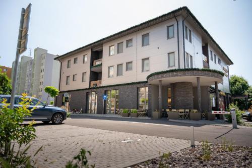 a building with a car parked in front of it at Emerald Residence Apartments in Dunajská Streda