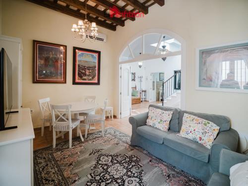 a living room with a blue couch and a table at Casa Guirigay in Sanlúcar de Barrameda