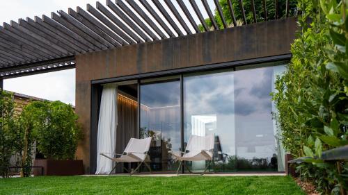 a pair of white chairs sitting on a patio at Villa Balis Crema Verona Hills in Grezzana