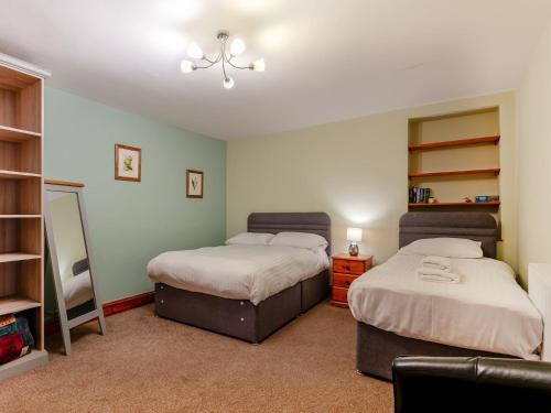 a bedroom with two beds and a mirror in it at 3 Bed in Crediton WAIEC in Zeal Monachorum