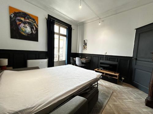 une chambre avec un grand lit et une fenêtre dans l'établissement Le Monkey Chic, central avec balcon, à Limoges