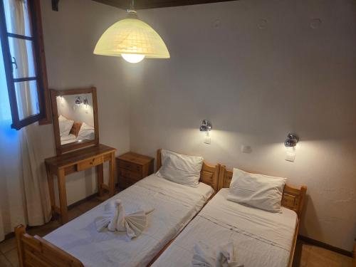 a bedroom with two beds and a mirror and a lamp at Zeus room 3 beds in Panagia