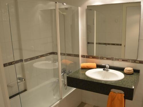 Un baño con lavabo y ducha de cristal. en Estartit Park 3-2, en Torroella de Montgrí