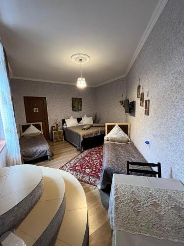 a hotel room with two beds and a living room at Mehriban Guest House in Sheki