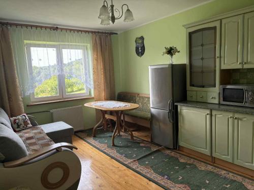 a small kitchen with a table and a refrigerator at Noclegi w Beskidzie Wyspowym in Przenosza