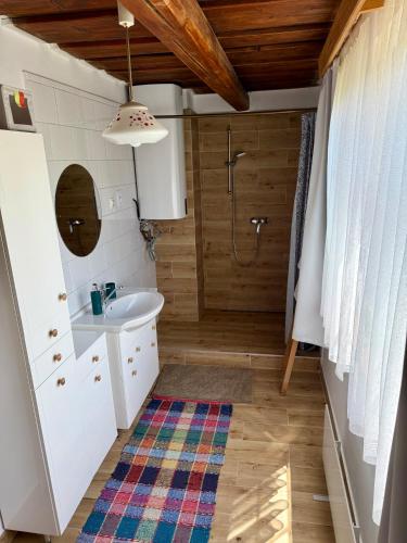 a bathroom with a white sink and a shower at Drevenica Linda in Liptovská Osada
