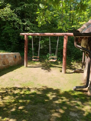 Un columpio en un parque con árboles al fondo. en Stari Vujadin, en Lazarevac