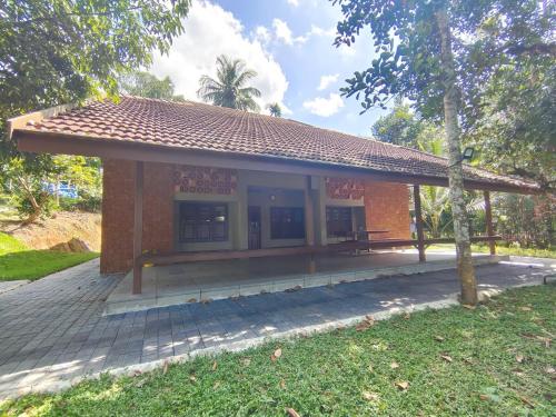 a small building with a bench in front of it at IRU Homes - Premium Pool Villa in Ambalavayal