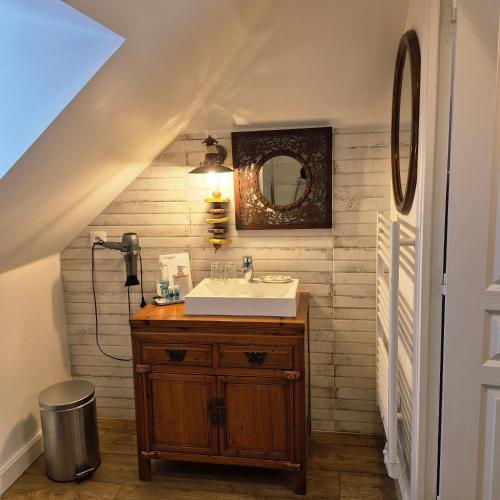 un bagno con lavandino e specchio di Maison d’hôtes KERGIQUEL a Paimpol