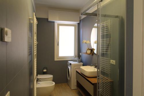 a bathroom with a toilet and a sink and a shower at Lussuoso Appartamento vista lago con spiaggia privata in Bardolino