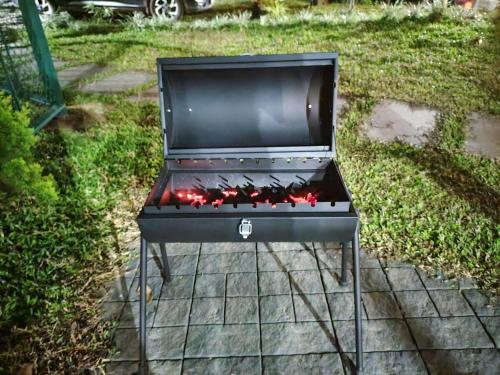 a bbq grill sitting on top of a yard at IRU Homes - Premium Pool Villa in Ambalavayal