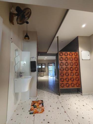 a bathroom with a sink and a mirror and a wall at IRU Homes - Premium Pool Villa in Ambalavayal