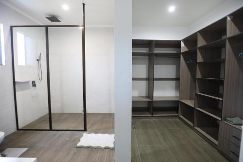 a bathroom with a shower and a glass door at Elizabeths Home Away From Home in Nadi