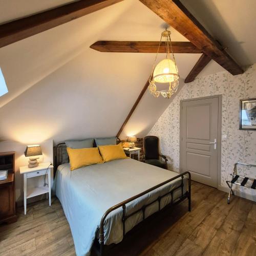 una camera da letto con un letto e un lampadario di Maison d’hôtes KERGIQUEL a Paimpol