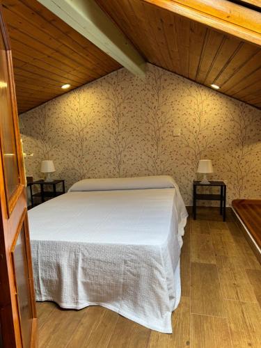 a bedroom with a white bed and two tables at Teresa's sweet home in Cudillero