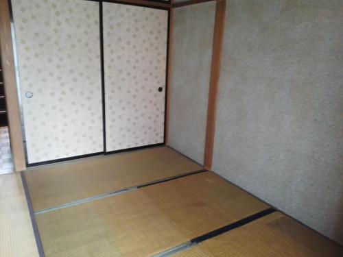 Guesthouse Face to Face في فوجينوميا: غرفه فاضيه فيها باب ودوره