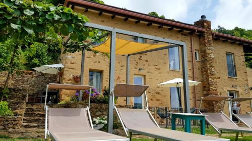 a group of chairs and umbrellas in front of a building at Bed and Breakfast Tenuta delle Stelle in Seravezza