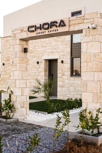 a brick building with a sign for a grocery store at Chora Luxury Suites in Paralia Dionysiou
