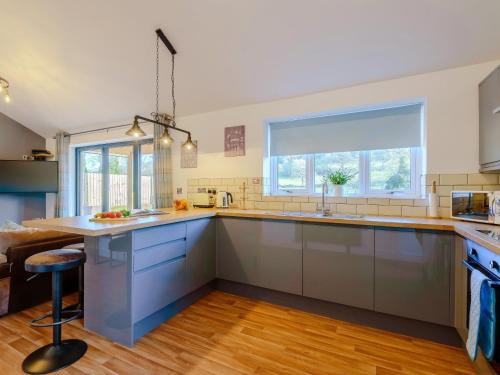 a kitchen with blue cabinets and a large window at 2 Bed in Bewdley 77721 in Highley