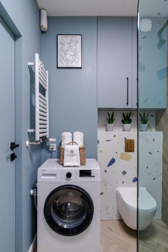 a washing machine in a bathroom with a toilet at Baltic Sands Apartment- 15 min Beach Free Parking Premium Letnica in Gdańsk