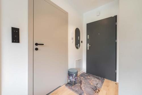 a hallway with a black door and a wooden table at Apartamenty Na Łąkach w centrum Ustronia in Ustroń