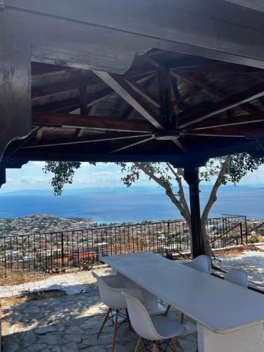 a white table and chairs under a blue umbrella at Eleni's Seaview House in Saronida