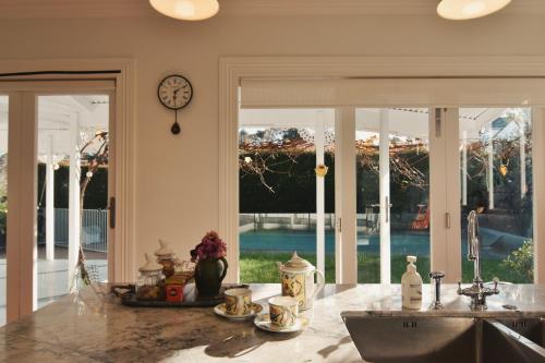 a kitchen with a sink and a clock on the wall at Welcome to Blue Morning house! - Remuera 5 bedrooms villa in Auckland