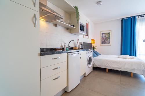 a kitchen with a sink and a bed in a room at Edificio Santiago by Plaza Mayor Apartamentos in Valladolid