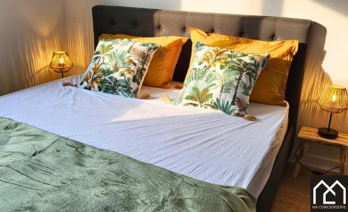 - un lit avec des oreillers jaunes et verts dans l'établissement Côté Remparts, Central, Face à la Vieille Ville & Parking Privé GRATUIT, à Boulogne-sur-Mer