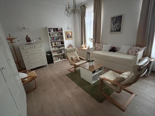 a living room with a couch and two chairs at Rózsakert Vendégház in Celldömölk