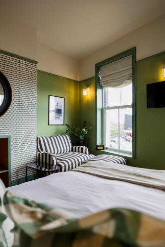 a room with two beds and a couch and a window at The London & Paris Hotel in Folkestone