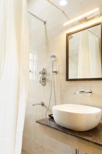 a bathroom with a white sink and a mirror at The Viva Grand in Chennai