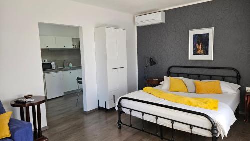 a bedroom with a bed with a yellow blanket on it at Apartments 4U in Omišalj