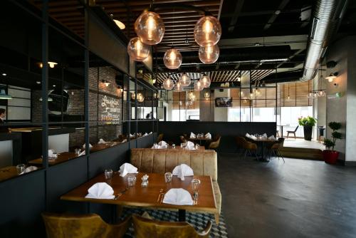 Un comedor con mesas, sillas y luces. en Park Inn By Radisson Istanbul Ataturk Airport, en Estambul