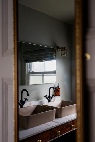 a mirror with two sinks in a bathroom at The London & Paris Hotel in Folkestone