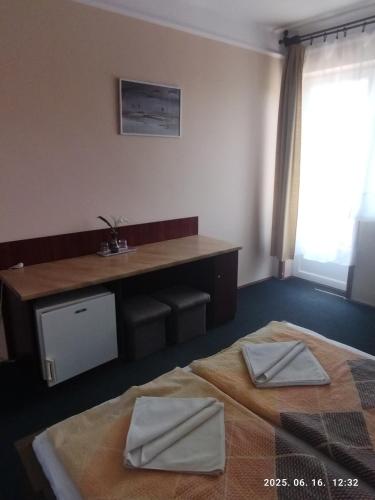 a hotel room with two beds and a desk at Start Panzió-Étterem in Hajdúszoboszló