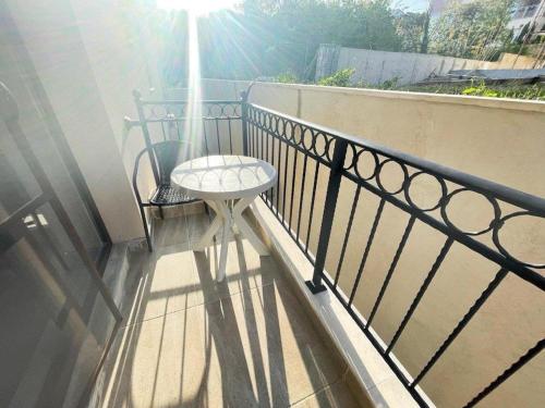 einen Balkon mit einem Tisch und einem Stuhl auf einem Geländer in der Unterkunft Studio Green Rublyovka in Warna