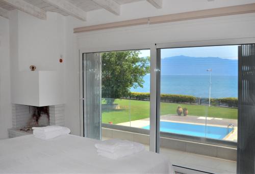a bedroom with a bed and a view of the ocean at Villa Al mare Stav in Kouvéla