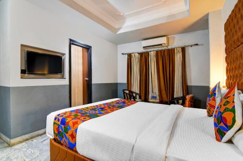 a bedroom with a large bed and a television at FabHotel Gulshan International - Nr Peter Cat Park Street in Kolkata