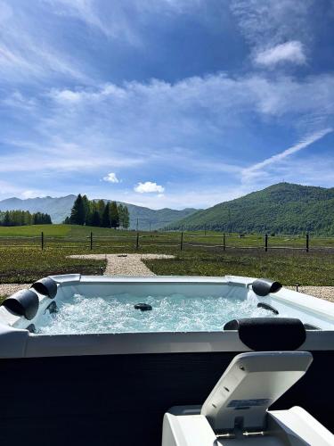 a hot tub with a view of a field at Golden Valley Brezna in Pluzine