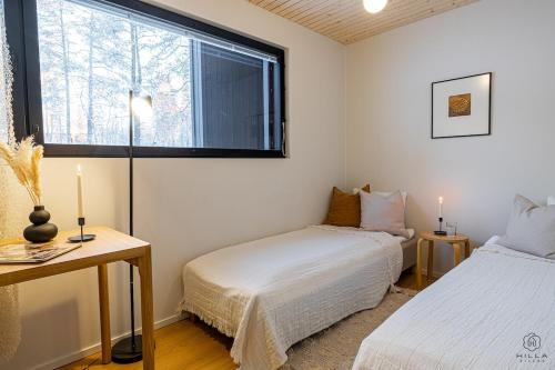 Un dormitorio con dos camas y una ventana en Villa Suunnikas by Hilla Villas, en Ylläsjärvi