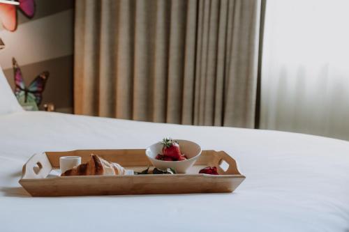 a tray with a bowl of strawberries and a plate of bread at Holiday Inn Salisbury - Stonehenge by IHG in Salisbury