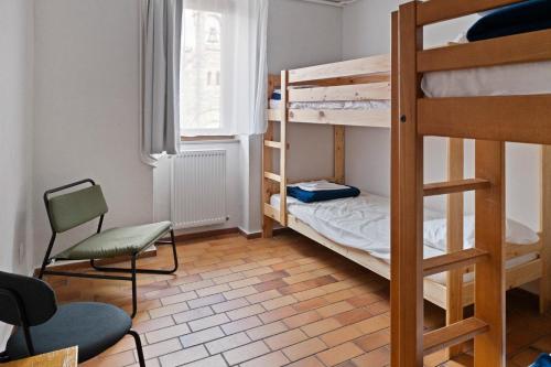 Cette chambre comprend 2 lits superposés et une chaise. dans l'établissement La Mansio de Bons, à Les Deux Alpes