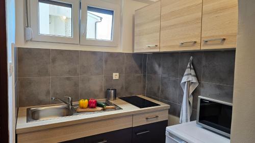 a kitchen with a sink and a counter top at Apartments 4U in Omišalj