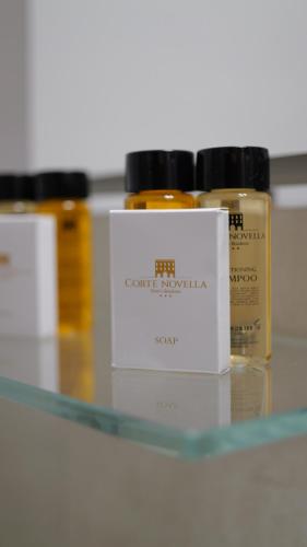 three bottles of essential oils sitting on a glass shelf at Corte Novella Hotel & Residence in Brescia