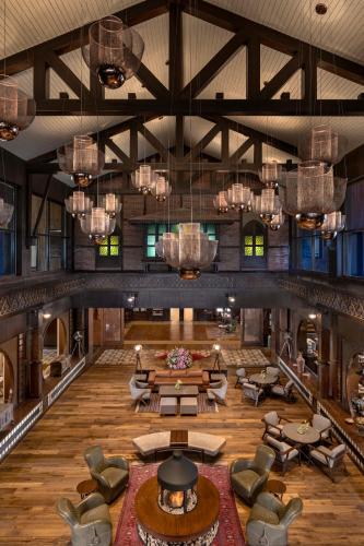 a large lobby with tables and chairs and chandeliers at The Khyber Himalayan Resort & Spa in Gulmarg