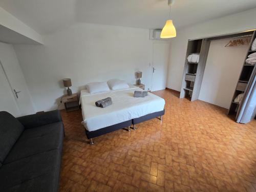 une chambre avec un lit blanc et un canapé dans l'établissement Raphaël, à Aix-les-Bains