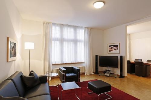 a living room with a couch and chairs and a television at Charming flat near lake - FB7 in Zürich
